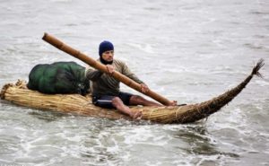 Man rowing his Totora reed raft in Peru